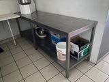 une cuisine avec une table et un seau posé par terre