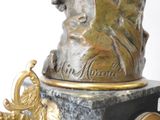a statue of a man with a hat on top of a clock