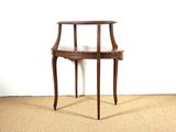 une petite table en bois avec un plateau en marbre, posée sur un sol recouvert de moquette