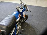 a blue motorcycle with a black seat on display