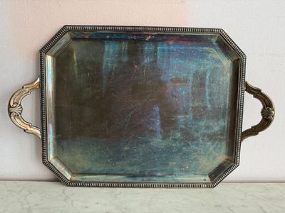 un plateau en argent avec un miroir sur une table