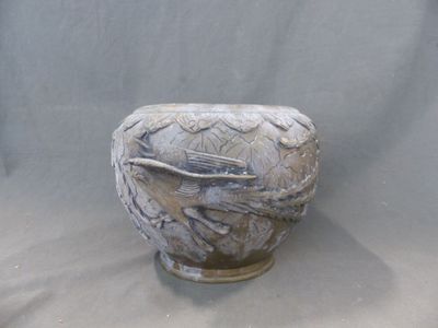 un vase avec un oiseau posé sur une table