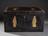 une vieille boîte noire ornée de motifs dorés sur les côtés