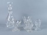 a glass decanter and four wine glasses on a table