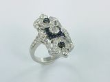 gros plan d'une bague en diamant et saphir sur une surface blanche
