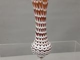 un vase en verre posé sur une étagère en verre
