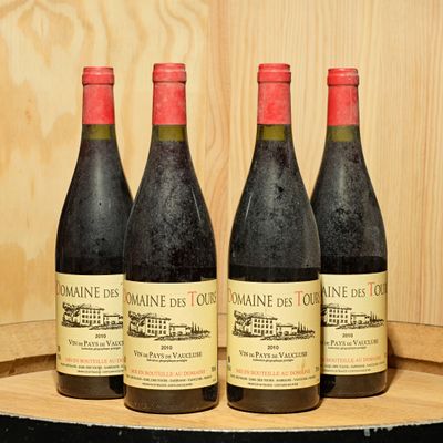 three bottles of wine sit on a wooden barrel in front of a wooden wall