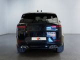the rear end of a black suv parked in a white room