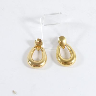 boucles d'oreilles en forme de larme plaquées or, présentées sur un support en acrylique transparent