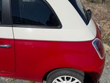 a small red and white car parked on the side of the road