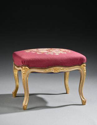 un tabouret rembourré doré et rouge, avec un coussin rouge