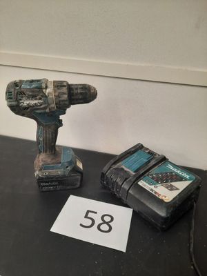 une perceuse et un livre posés sur une table