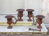 four rusted metal urns sitting on the steps of a house