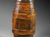 an old wooden barrel with writing on it sitting on a table