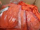 a cardboard box filled with orange clothing and a pair of scissors