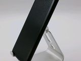 a cell phone that is on a stand on a white surface