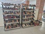 many pairs of shoes on the shelves in the store