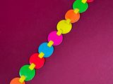 a close up of a colorful bracelet on a purple surface