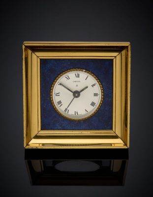 a small square clock with roman numerals in a gold frame