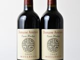 deux bouteilles de vin rouge posées sur une table en bois