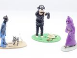 three figurines of a man in a purple robe and a man in a purple robe