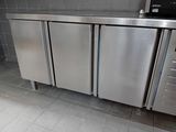 a stainless steel refrigerator in the middle of a tiled floor