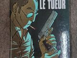 the cover of the book le tueur, with a man holding a gun and smoking a cigarette