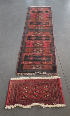 deux tapis rouges et noirs posés sur un sol gris