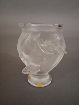 un vase en verre orné d'un oiseau, posé sur une table