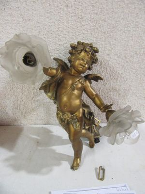 a small statue of a cupid holding a flower on a table