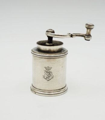 an antique silver coffee grinder on a white background