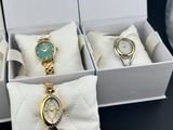 three watches in a box with a bow tie on a table