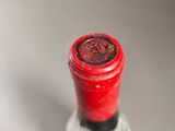 a close up of a bottle of wine with a red cap