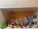 de nombreux verres à vin posés sur une étagère dans la cuisine
