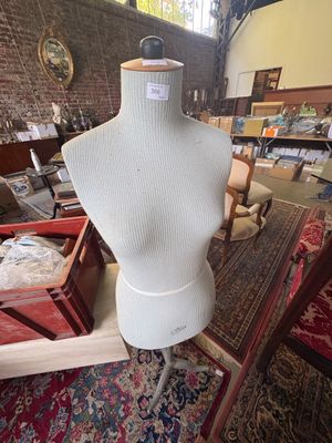 a mannequin on a stand in a room full of furniture