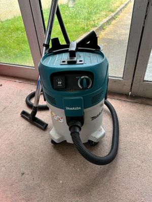 a vacuum that is sitting on the floor by the window