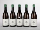 quatre bouteilles de vin sont alignées sur une surface blanche