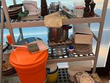 a metal shelf with a bucket and a bucket on top of it