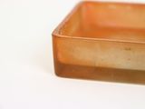 a small square glass container sitting on a white surface