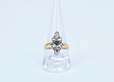 un gros plan d'une bague en or et en argent sertie d'une pierre verte