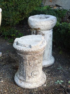 deux urnes en ciment posées l'une à côté de l'autre sur le sol