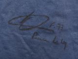 blue t - shirt with black writing on the front and a picture of a man ' s hand holding a tennis racquet