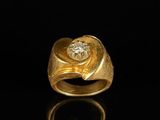 a close up of a gold and diamond ring on a black surface