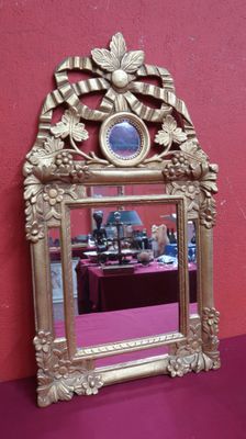 a mirror that is sitting on a table in front of a pink wall