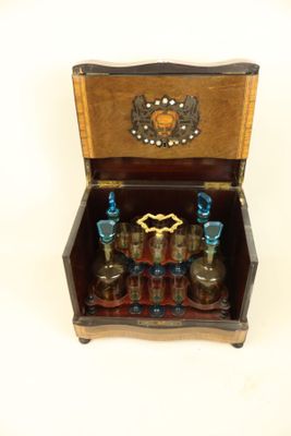 a small wooden box with several bottles inside of it
