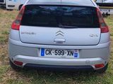 the back of a silver citrole parked in a grassy field
