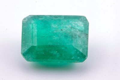 gros plan d'une pierre d'émeraude verte sur une surface blanche