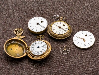 quatre montres de poche différentes posées sur une table