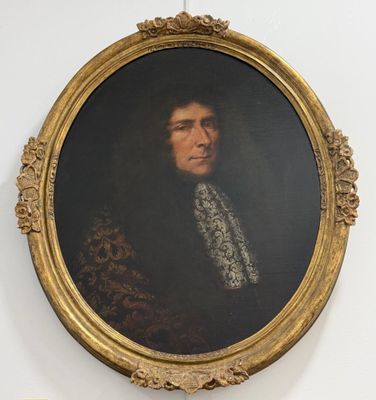 portrait of a man in a gold frame with a white collar