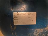 un vase bleu sur lequel est accrochée une étiquette